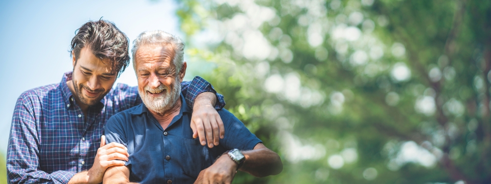 Elderly man with younger man embracing