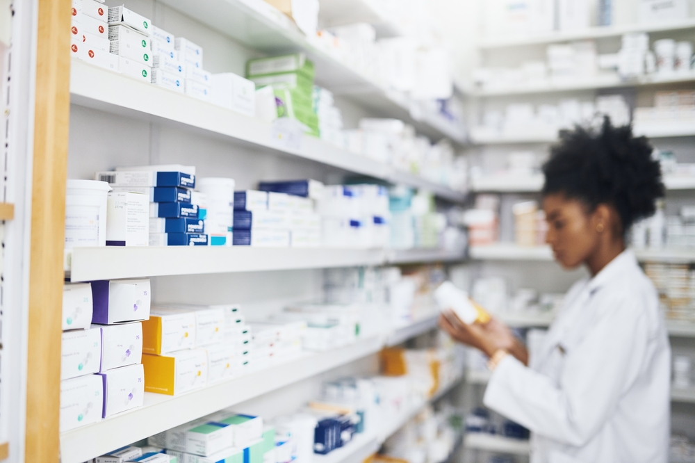 blurred pharmacist in a pharmacy surrounded by medications 